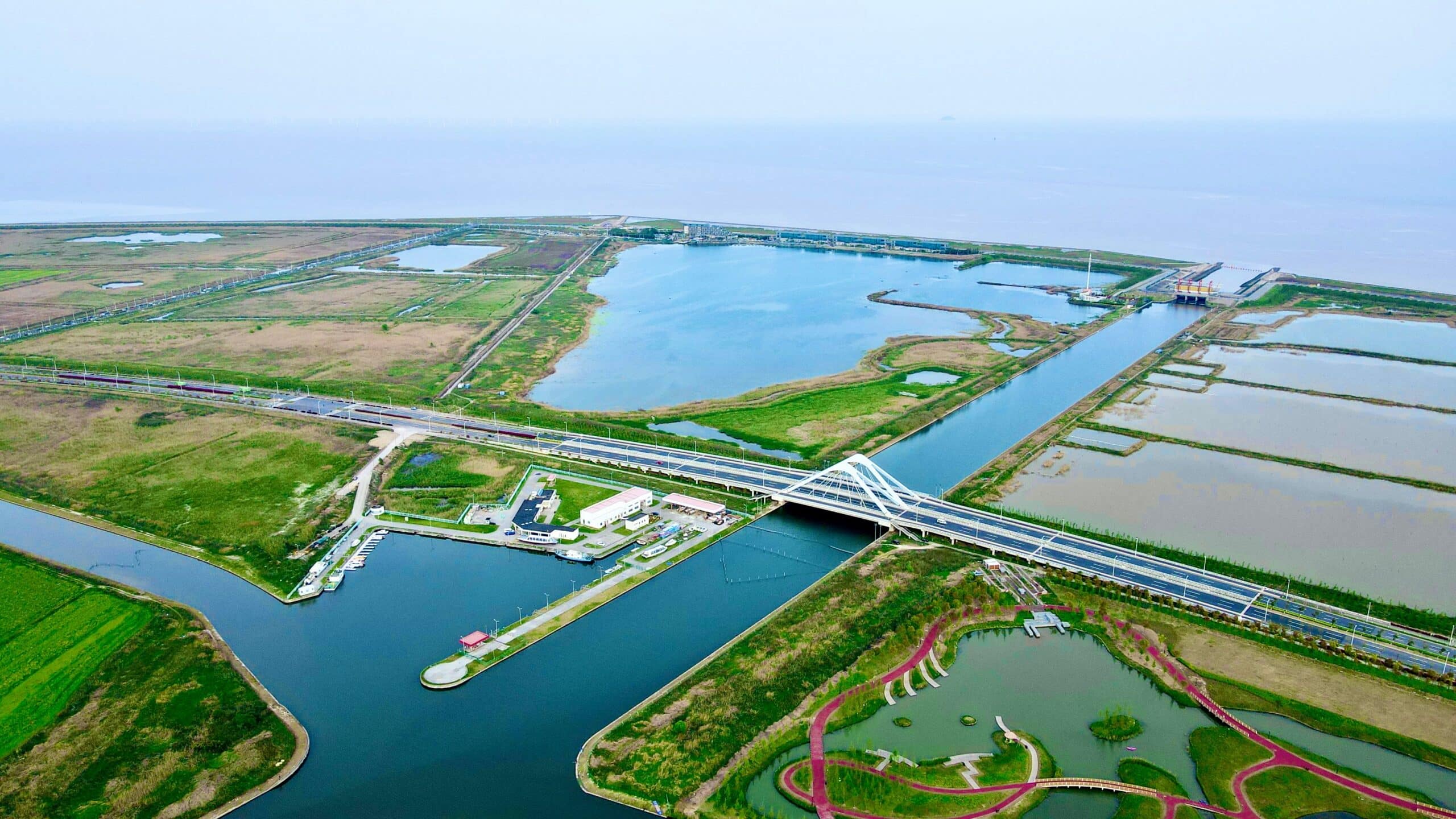 Breathtaking aerial view of Shanghai's waterways and fields under a clear sky.